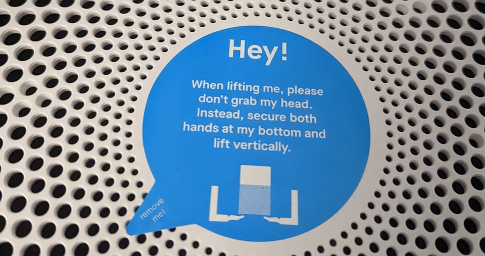 A sticker from the top of an air purifier (I think) which says Hey! Don't grab my head!