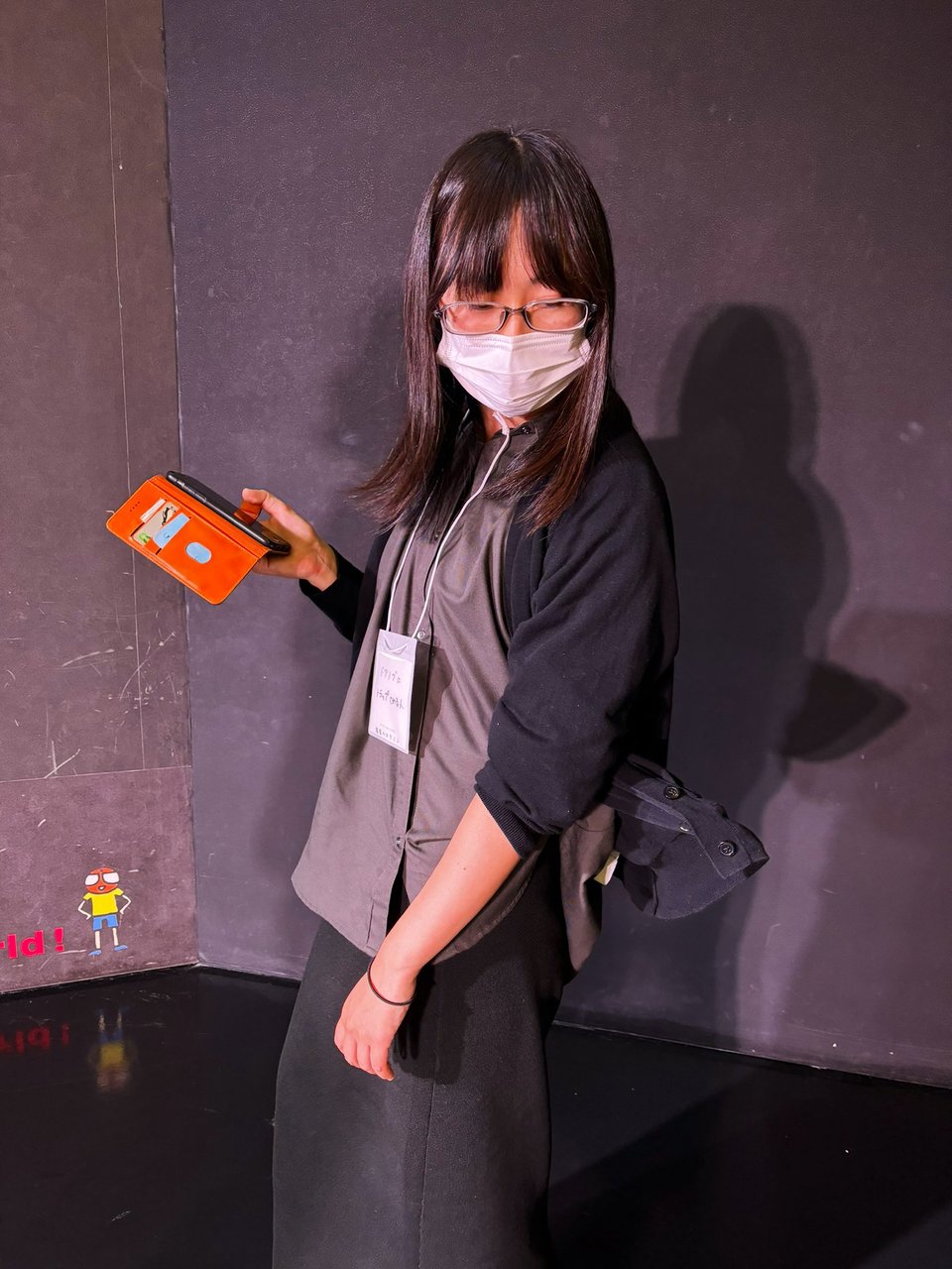 A woman turns to see why her pocket is caught on something (in this case, an invisible doorknob; the pocket is held up with wire or something similar)