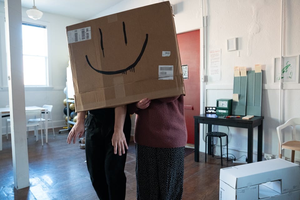 Lizzie and Dan wearing a box mask.