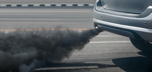 A load of black smoke coming out of a car exhaust