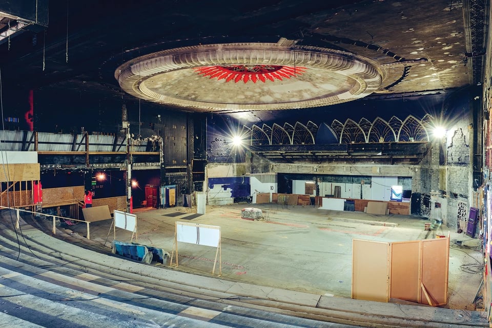 The semi-derelict inside of the Millenium nightclub. At the far end are hints of some deco stylings, and in the foreground are the steps that would have once held the ranked seating of the circle. Above the abandoned dancefloor is a huge decoration that looks more like a stargate portal than anything else.