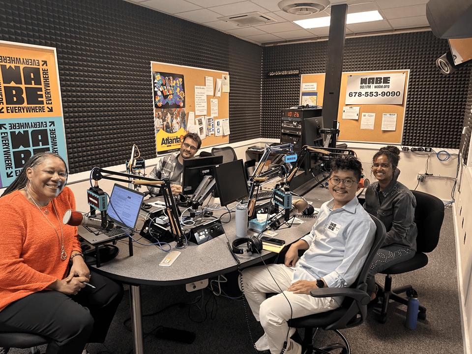 Four journalists sit in a WABE studio