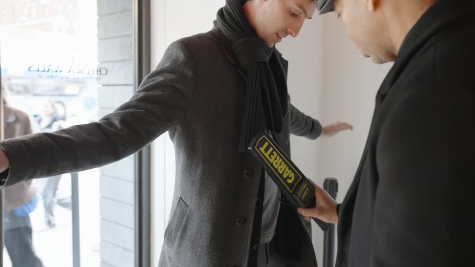 security detail screens guest with metal detector