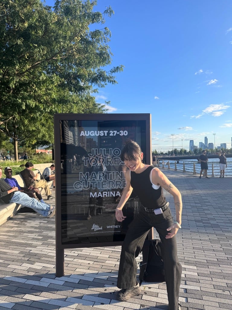 Photo of me in front of a Marina poster on Little Island