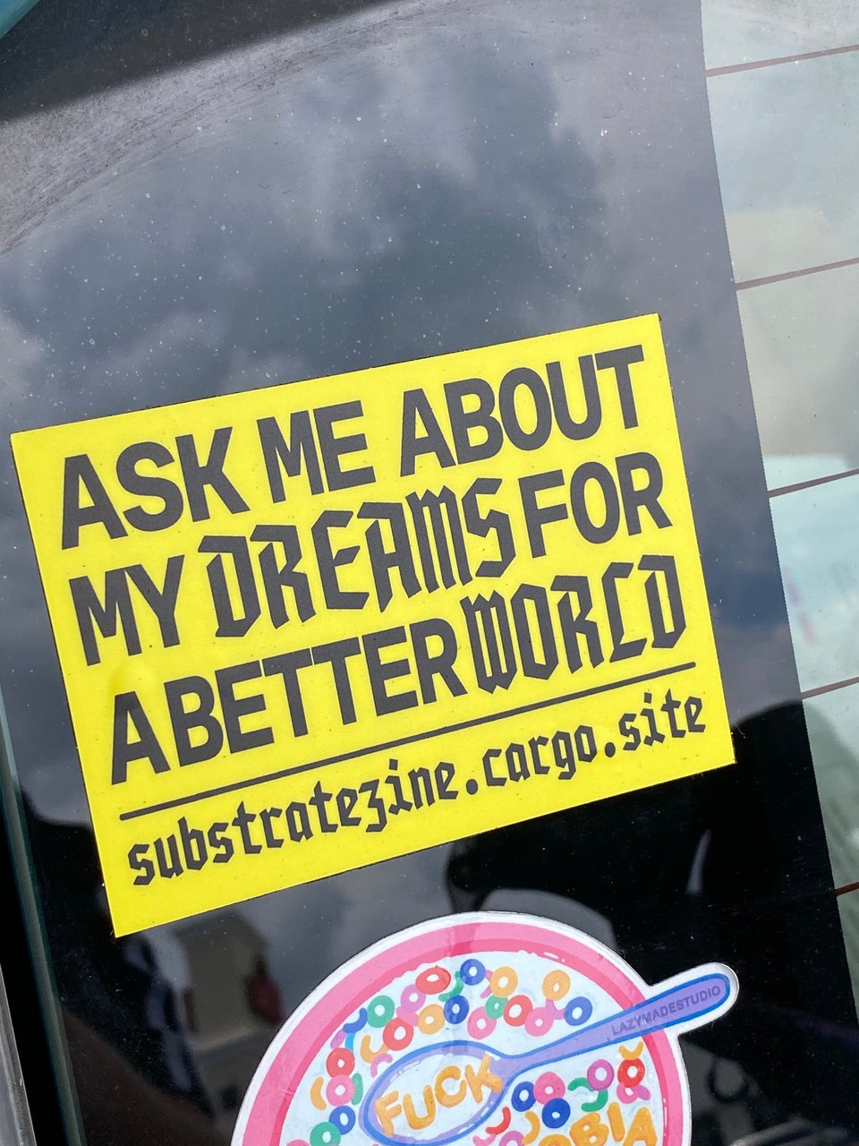 a picture of a sticker on my car. it reads, "ASK ME ABOUT MY DREAMS FOR A BETTER WORLD - substratezine.cargo.site "
