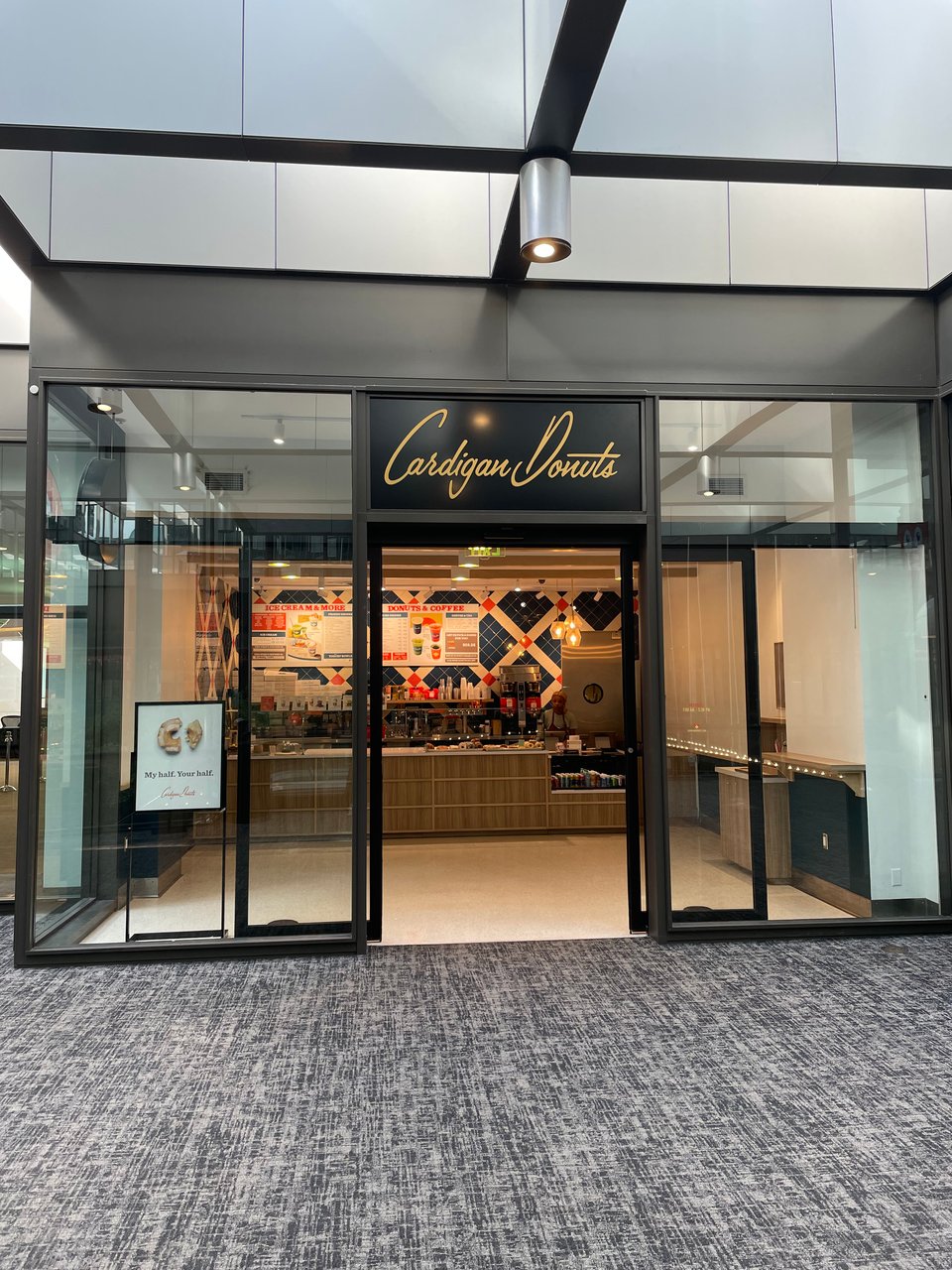 A blue and red donut shop with fancy cursive writing proclaiming Cardigan Donuts