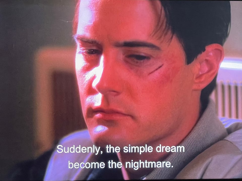 A screen capture from the TV show Twin Peaks. Agent Cooper is bruised and pensive. A subtitle reads: Suddenly, the simple dream become the nightmare.
