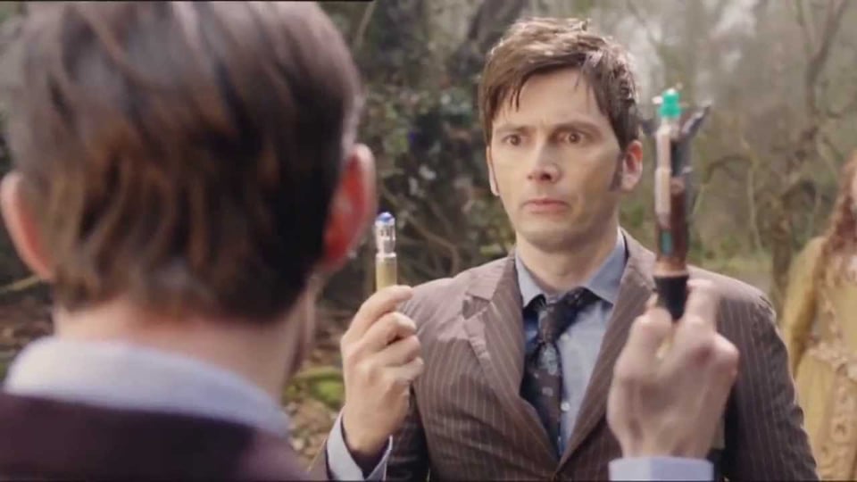 The Tenth Doctor holding his Sonic Screwdriver, looking sheepish at Eleven's bigger one.