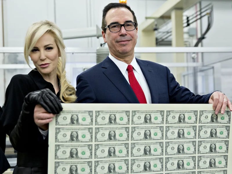 Former Treasury Secretary Steven Mnuchin and his wife Louise Linton hold a 2017 sheet of $1 notes bearing Mnuchin’s name for a photograph at the US Bureau of Engraving and Printing in Washington, DC, in 2017. Andrew Harrer/Bloomberg via Getty Images
