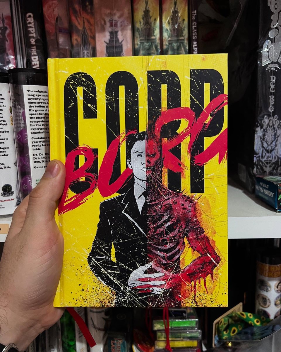 A hand holding the hardcover book Corp Borg, depicting a half executive half bloody undead creature.