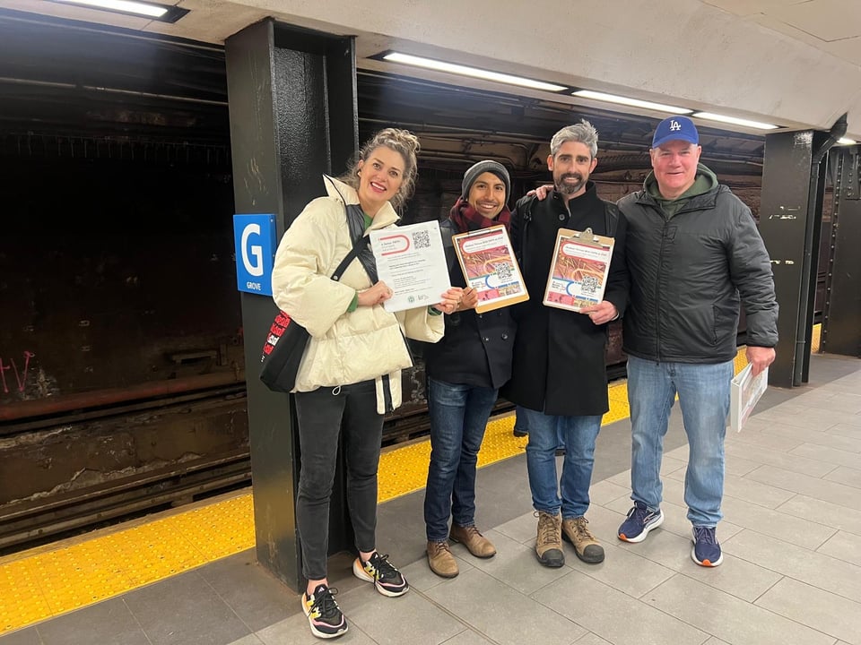 This image shows four campaign members canvassing at the Grove St station for better PATH service.
