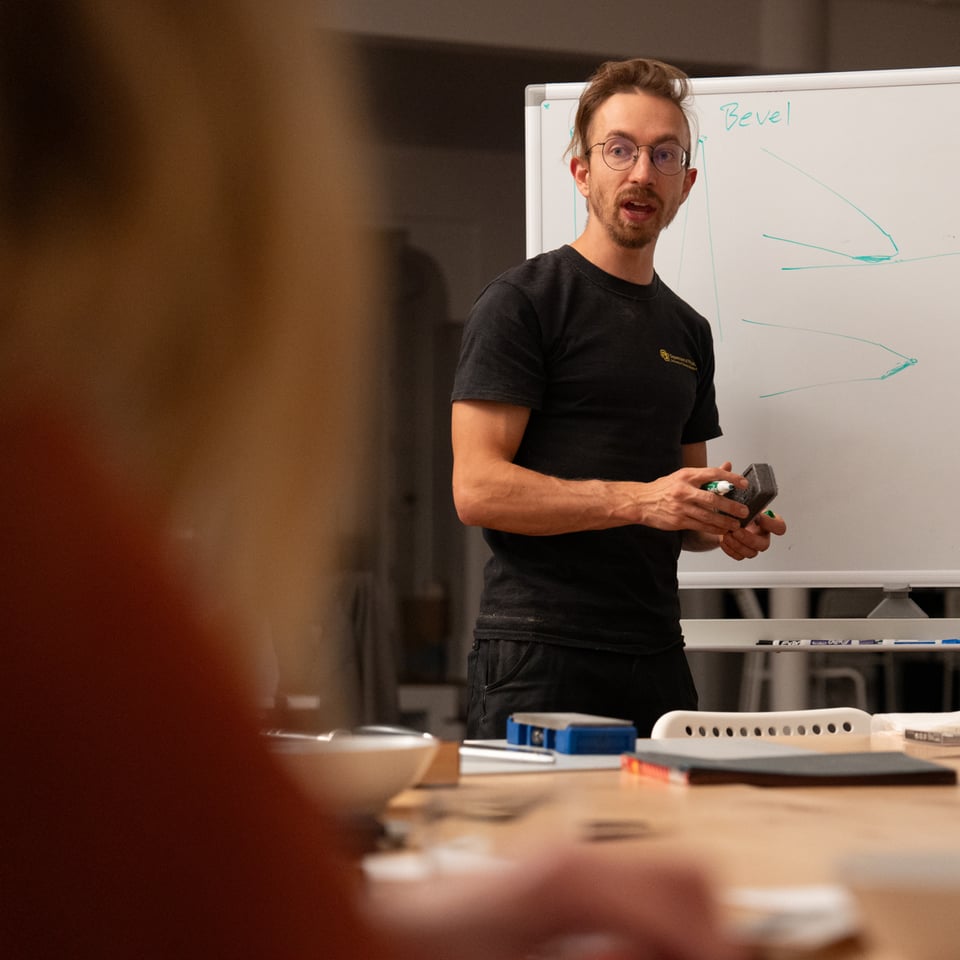 Elijah drawing knife stuff on a whiteboard.