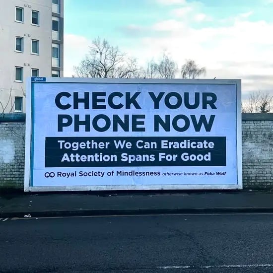 Billboard reads: Check your phone now / Together we can eradicate attention spans for good / Royal Society of Mindlessness