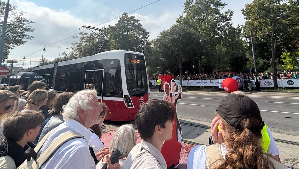 A tram, a big ball, a bunch of people watching eagerly