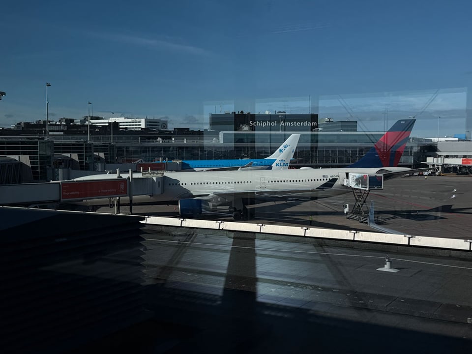 View of Schiphol Amsterdam airport with two planes parked at the terminal.