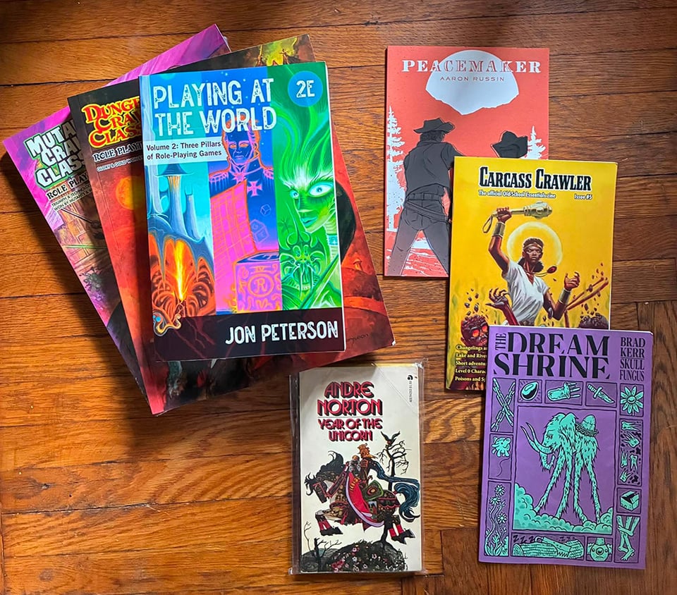 The books I bought at Gen Con, arranged on a hardwood floor. The books themselves are discussed in the text below. Note that Year of the Unicorn has a cool cover.