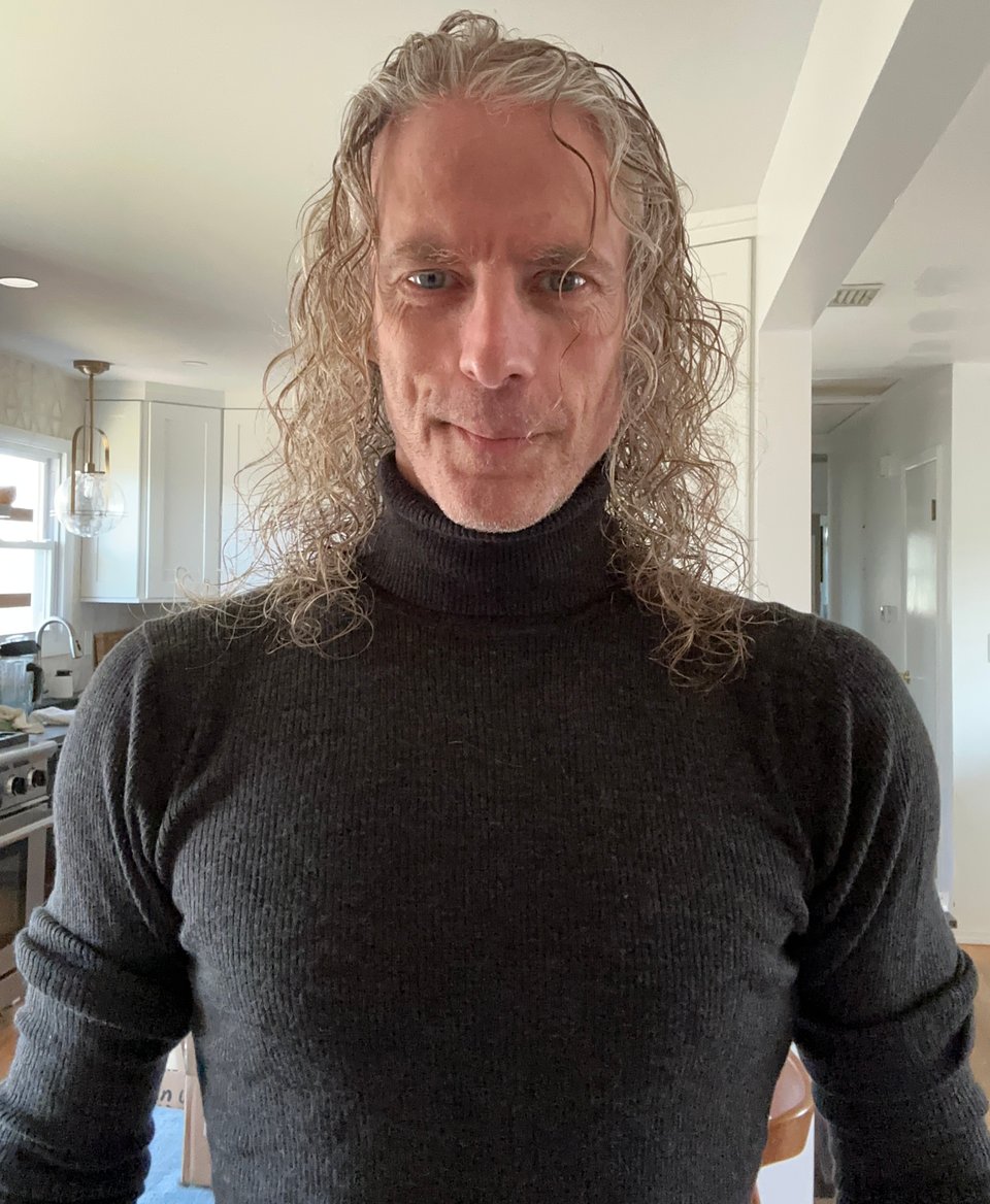 selfie of white man with long hair in a dark gray ribbed turtleneck