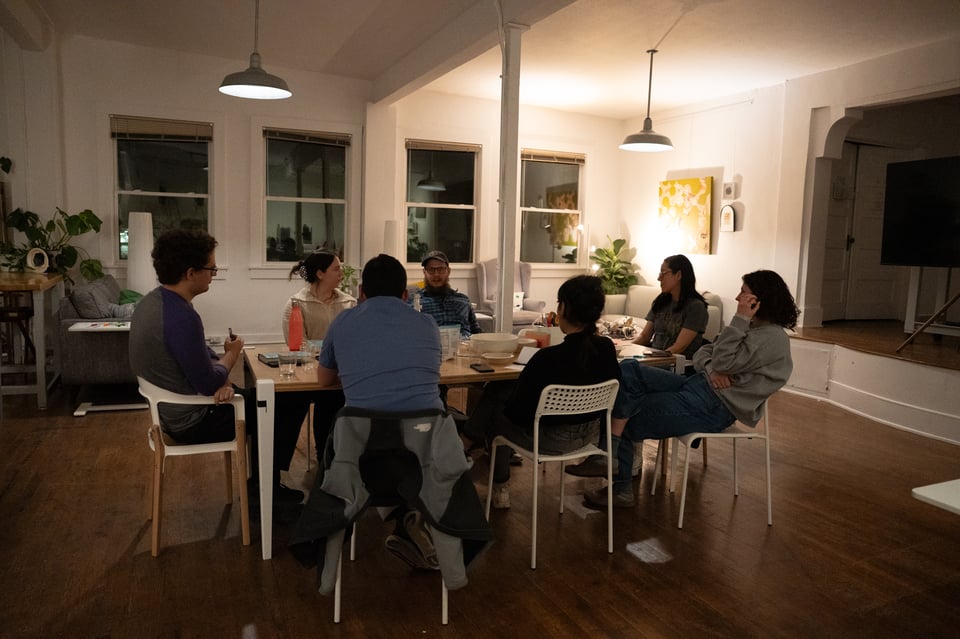 A group sitting at a table discussing a book.