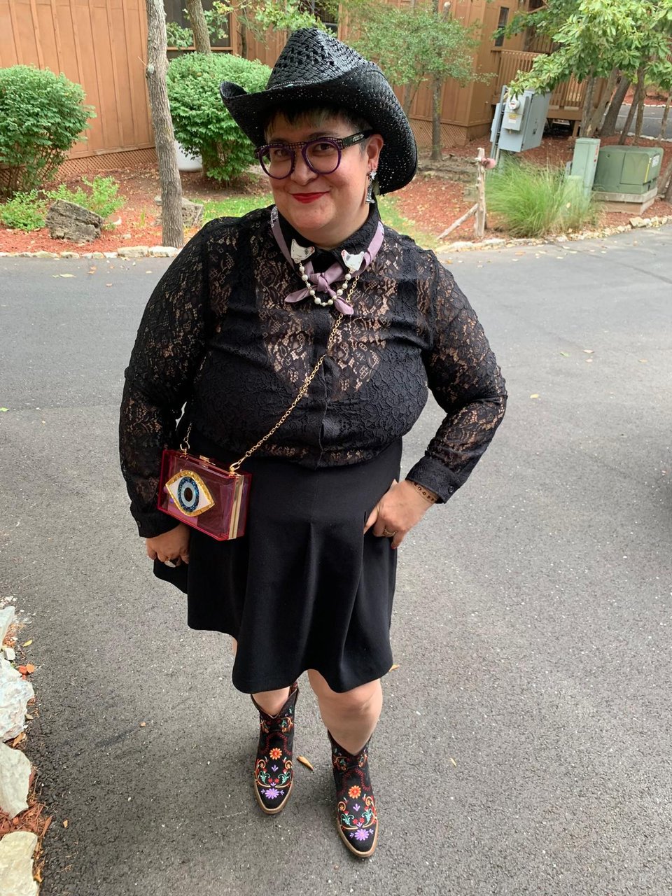A chicanx person in black cowboy gear