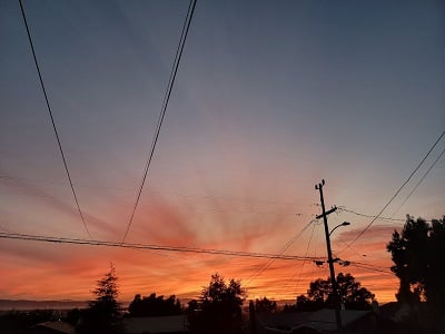 A sunset a bit obscured by phone wires and telephone poles