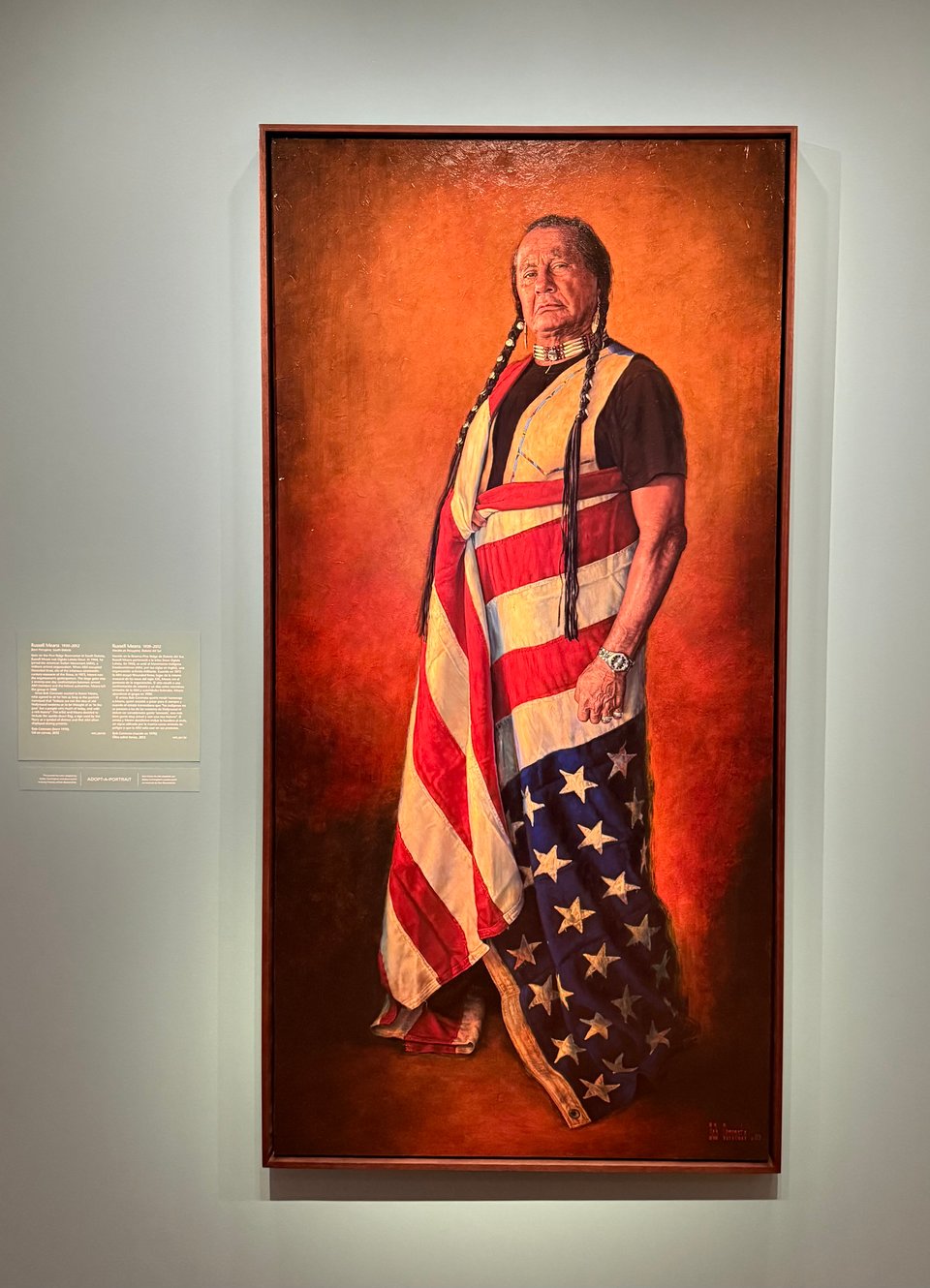 portrait of Native American Russell Means, wearing an upside-down American flag.