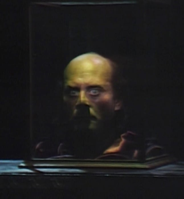The disembodied head of Judah Zachary, in a glass case, on a table in a darkened room. His eyes, unpleasantly, are wide open.