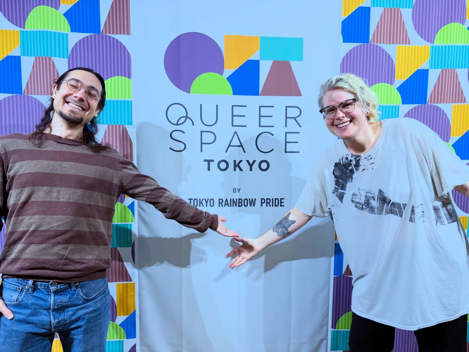 Two people with their arms outstretched, smiling.