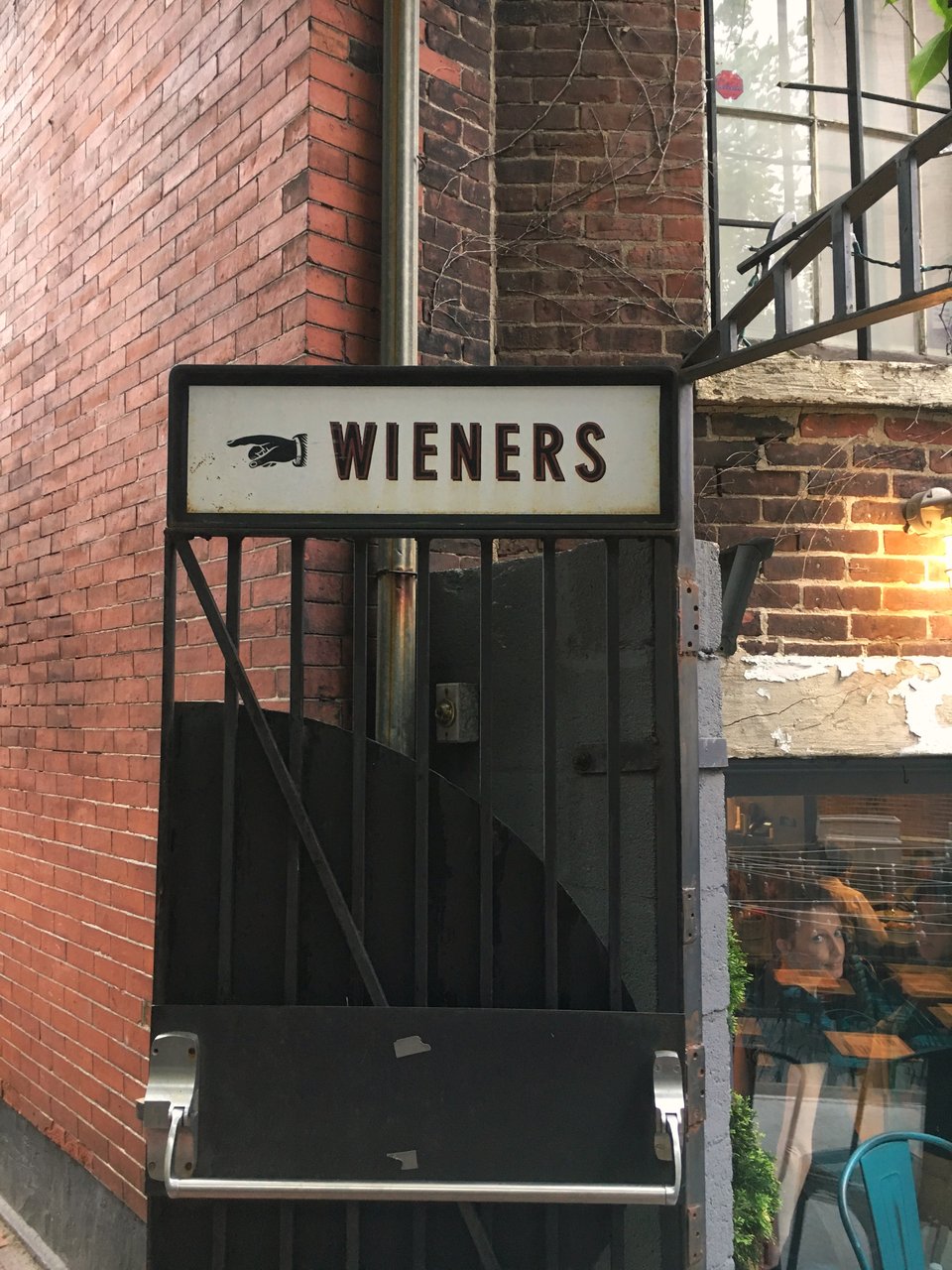 a door sign that says "wieners" with an arrow