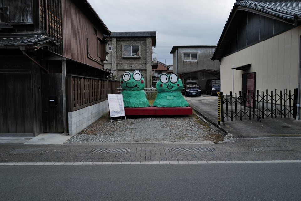 two green frog monsters on a street
