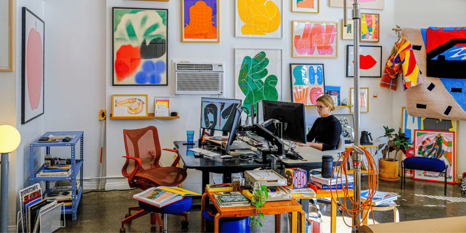 A beautiful working space with large colourful graphic prints on the wall.