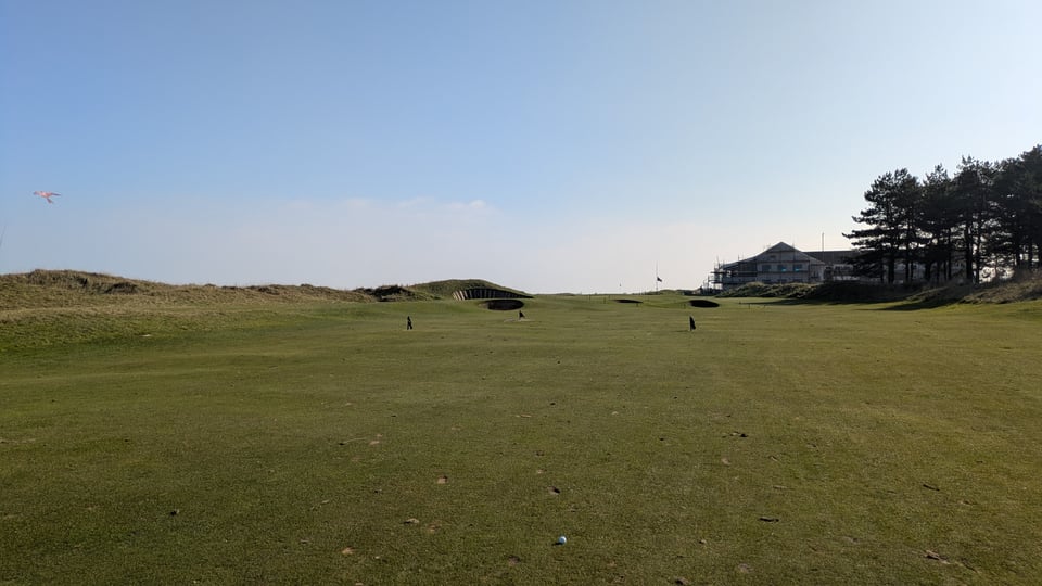 Ball in the middle of the fairway 120 yards uphill to the finishing green and clubhouse, several deep bunkers guarding the green