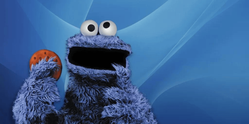 Cookie Monster, a blue fuzzy monster, eats a cookie.