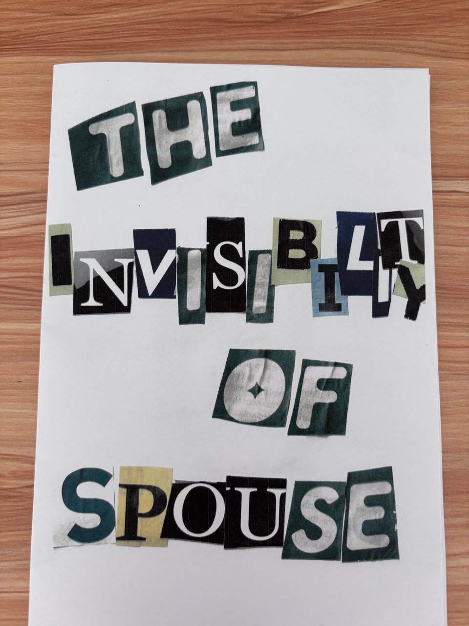 A piece of paper with the text "THE INVISIBILITY OF SPOUSE" written out in cutout pieces of letters from magazine pages.