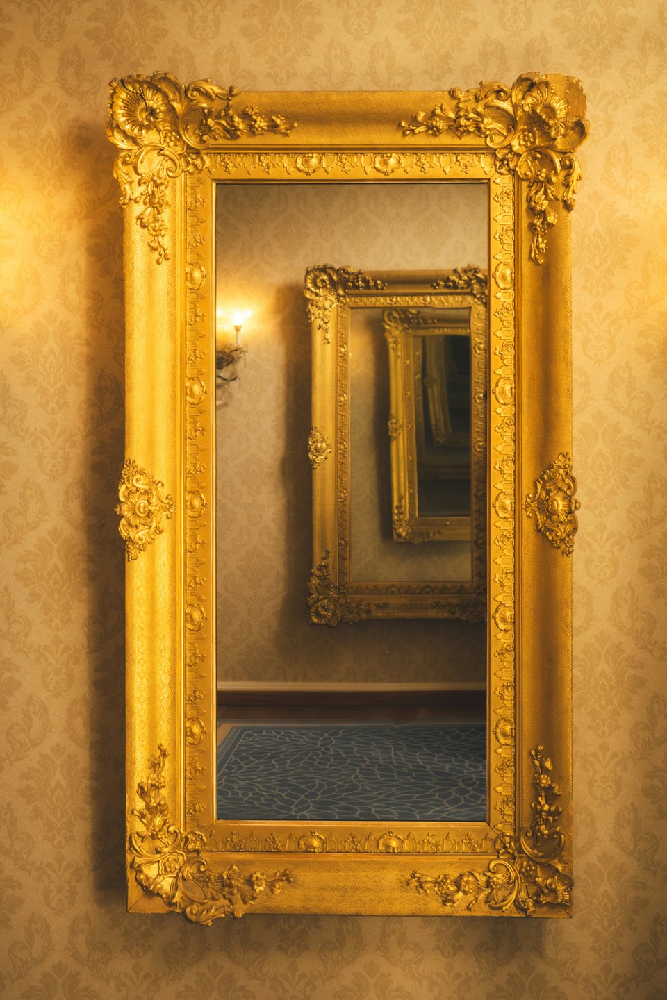 A mirror on the wall, showing a row of endless mirrors as there seems to be the same mirror hanging on the opposite wall.