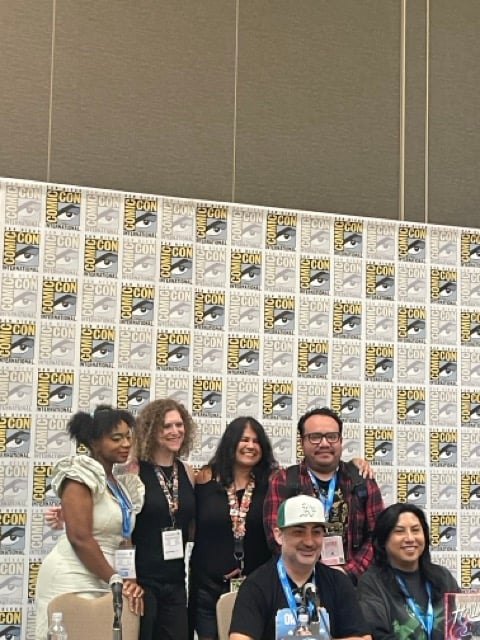 Panelist infront of SDCC step and repeat at SDCC
