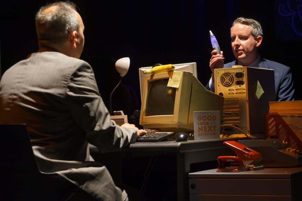 2 actors behind their office desks