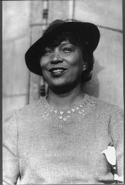 A black and white photograph of Zora Neale Hurston wearing a terrific sweater and hat