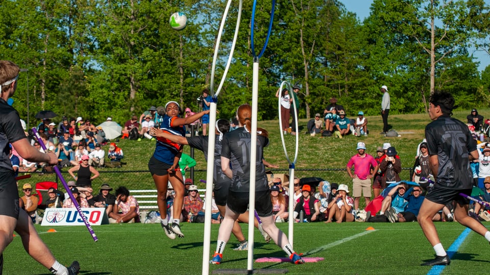 UVA Chaser in blue/orange passes the ball over the hoops as Creighton in black defends