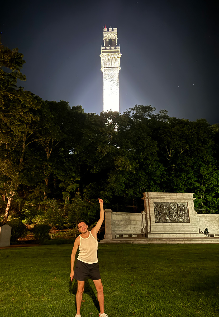 The author pointing up at an illuminated granite tower.