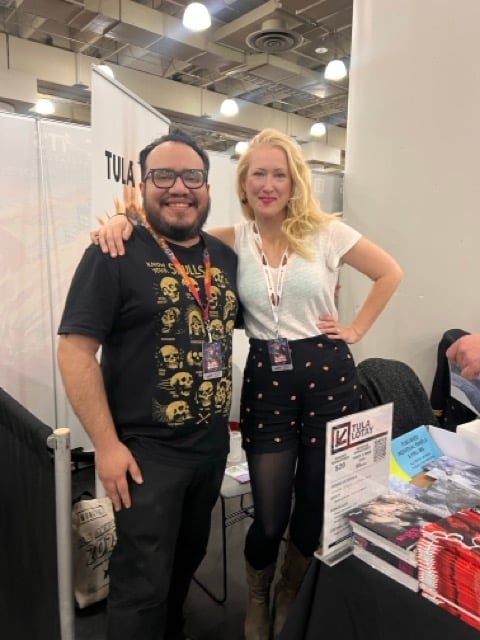 a man and woman standing next to each other at a convention