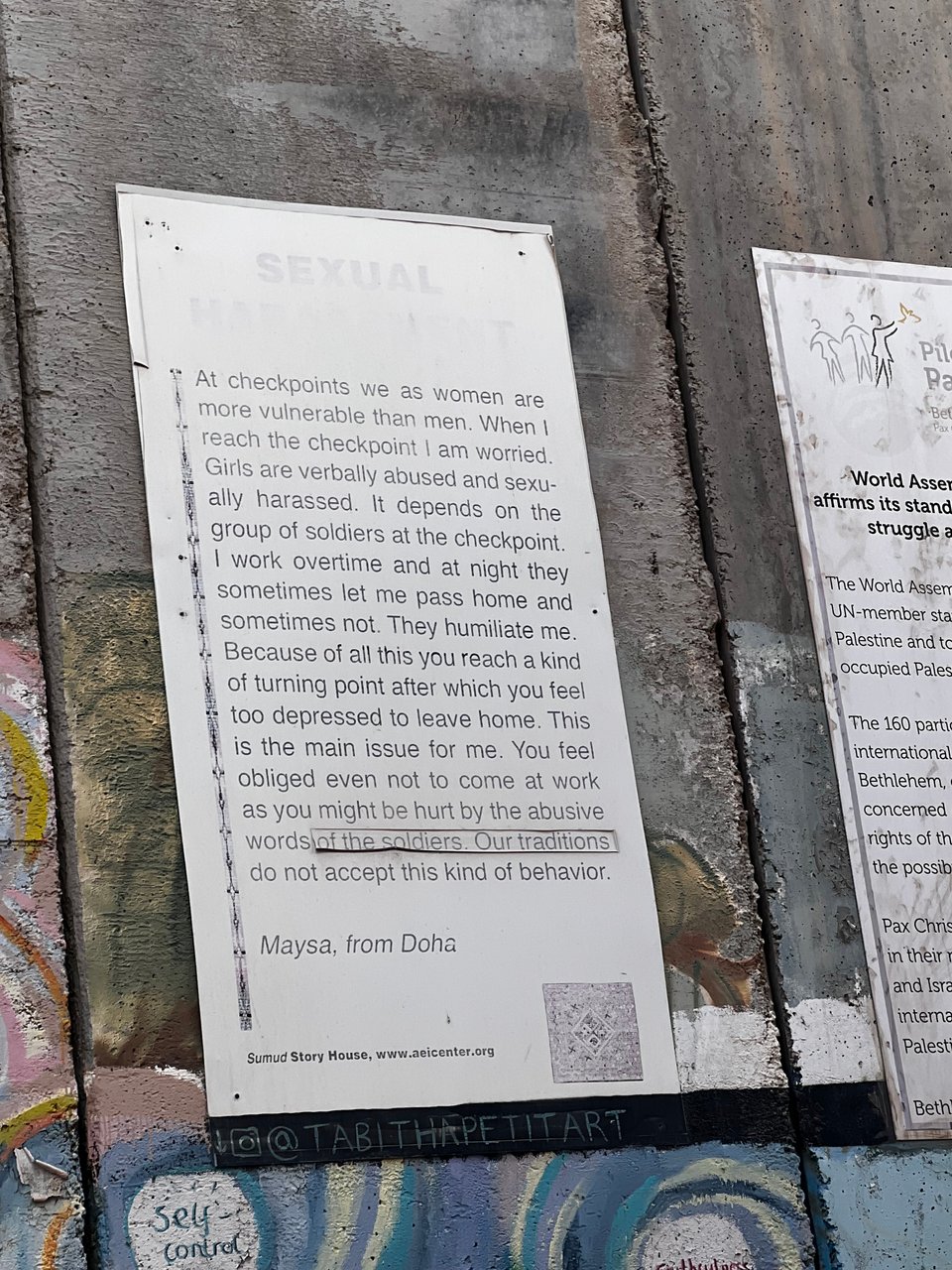 A poster affixed to a large concrete wall.  The text on the poster is shown in the caption below