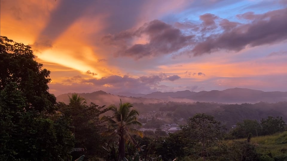 The sun rises over a mountain landscape