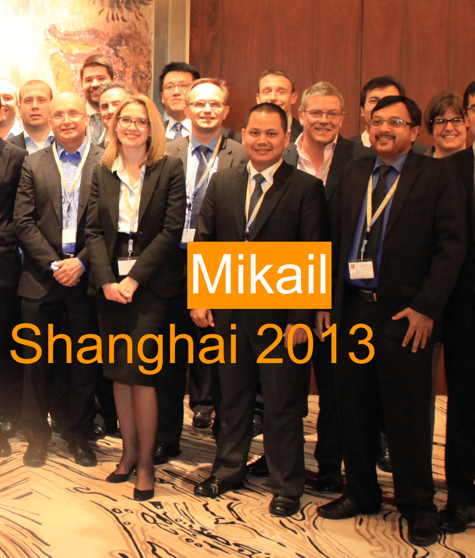Close-up detail from the photo above showing a young man in the front row with cropped hair and a big smile, with words superimposed over the picture: “Mikail, Shanghai 2013”.