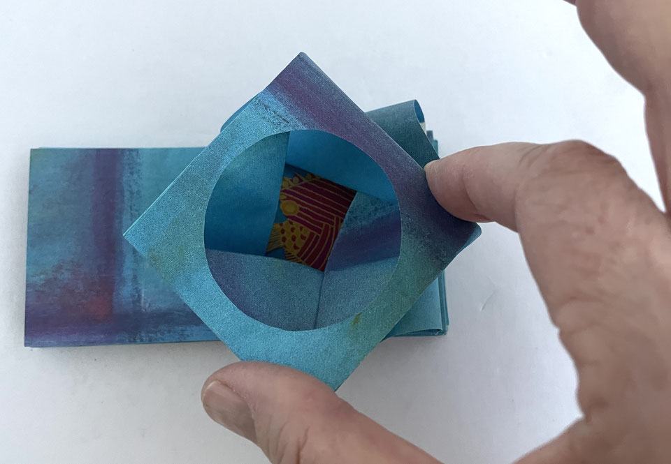 Un papier plié qui s'ouvre comme un oeil de caméra