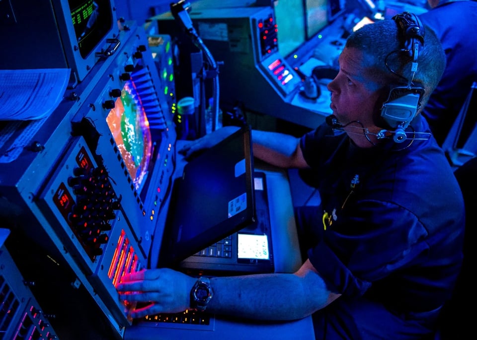 Navy man at a Navy screen doing Navy things