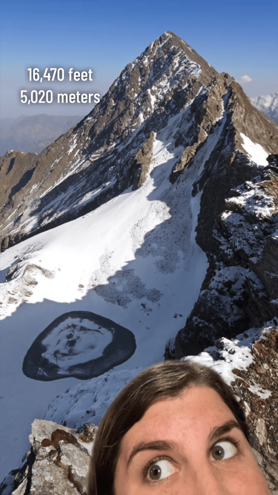 A screencap showing a woman superimposed over a mountain. It's labeled
