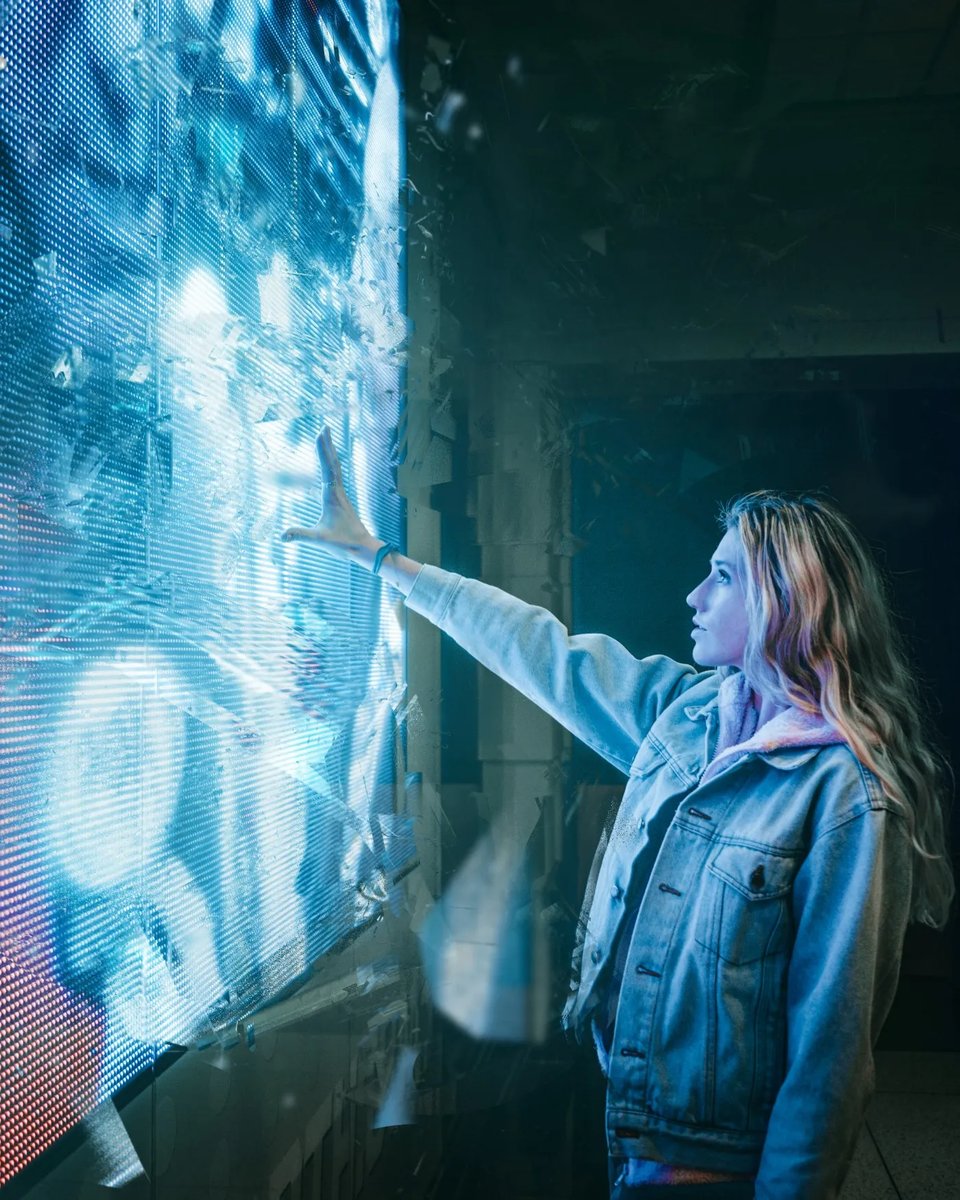 a woman pointing at a screen in a dark room