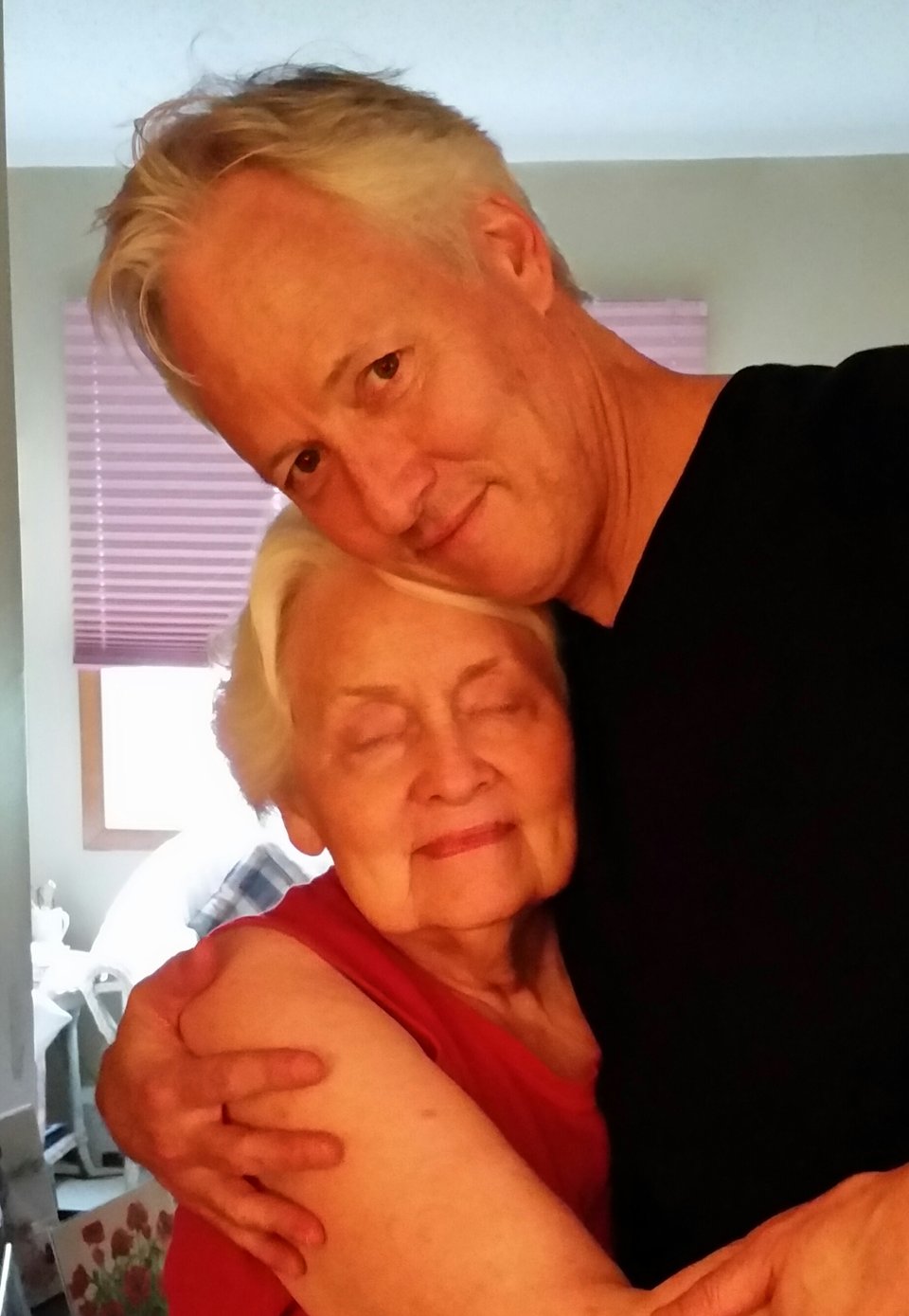 Photo of Shirley Biewen and John Biewen hugging -- Shirley's eyes are closed.