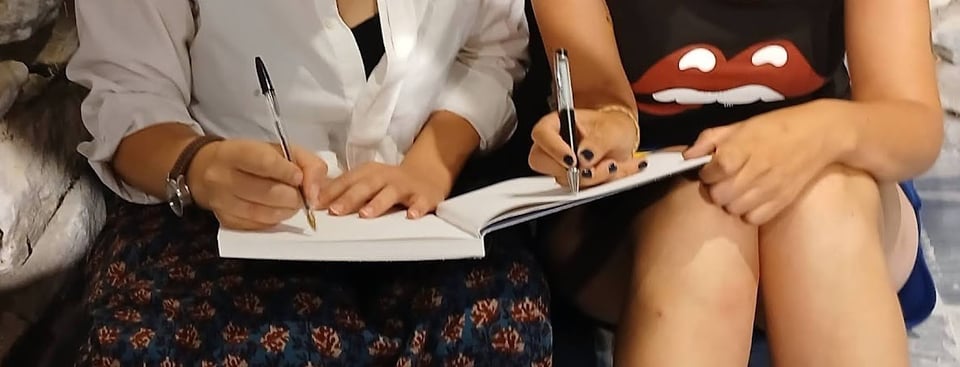 Deux personnes écrivant sur un même carnet