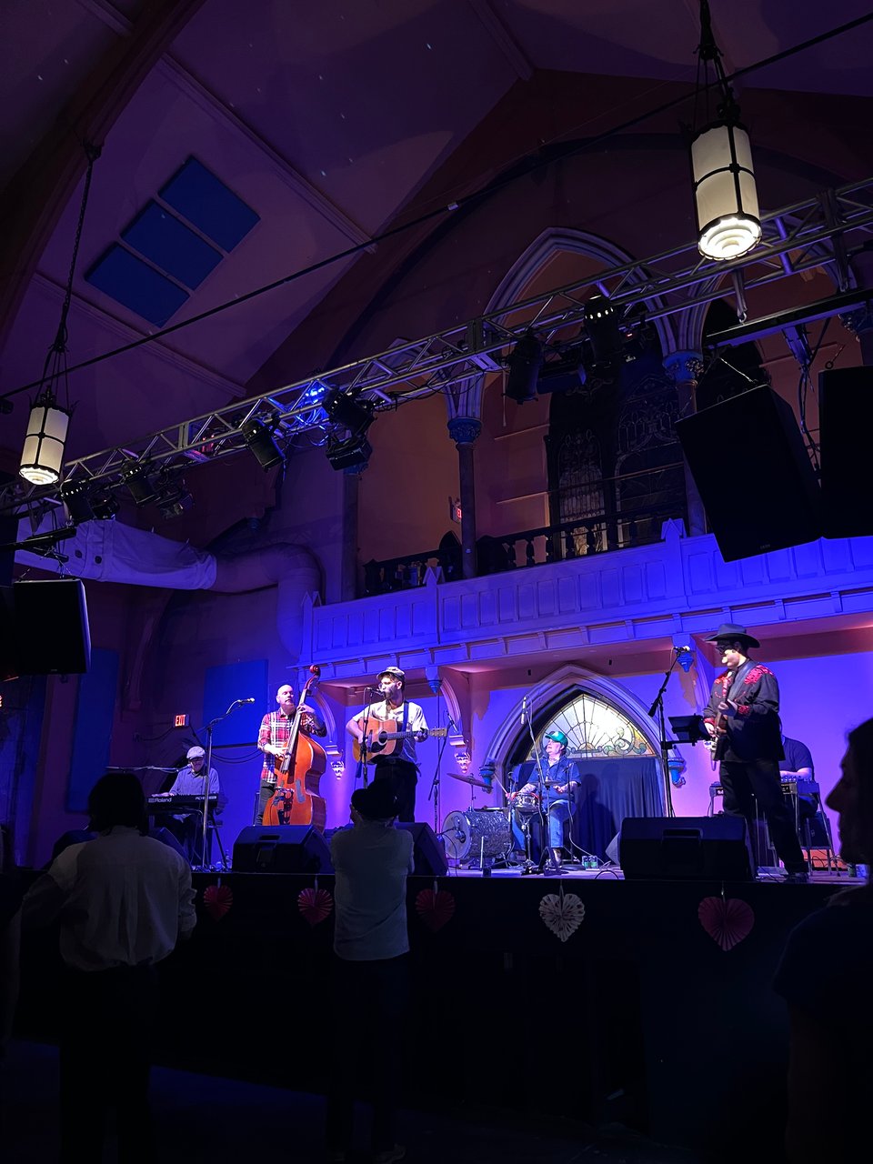 Color photograph of Joe's Truck Stop bluegrass band, depicting five musicians with instruments on a stage.